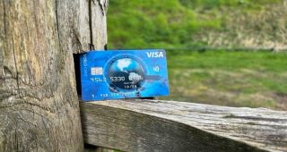 Een Visa World Card op een hek